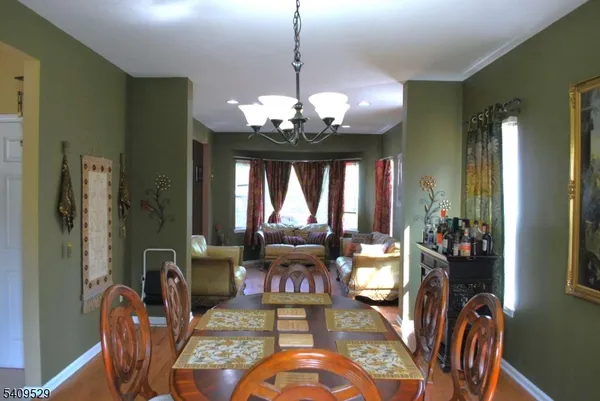 a view of a dining room with furniture wooden floor and chandelier