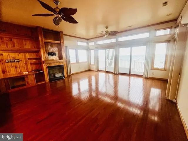 a kitchen with stainless steel appliances kitchen island granite countertop a refrigerator a stove and a wooden floors