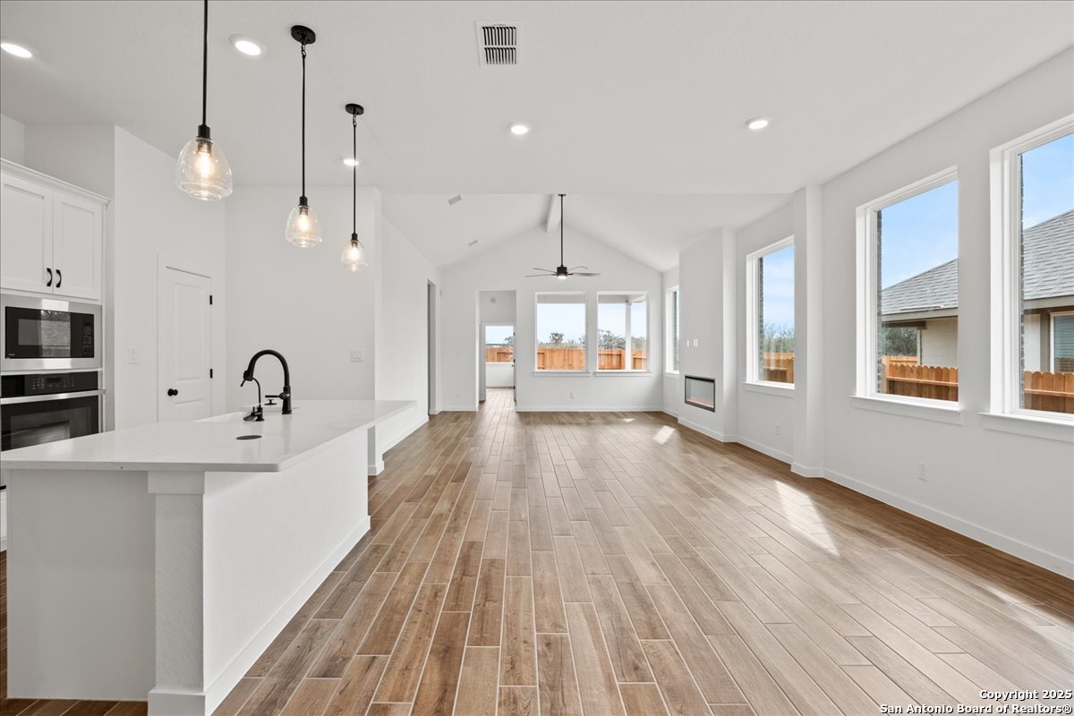 2013 Shepards Street Seguin, TX 78155 - Photo 3 of 21 a view of a kitchen with kitchen island a sink wooden floor and a large window