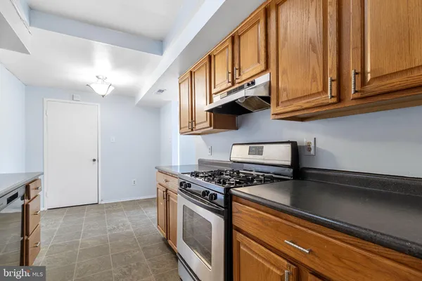 a kitchen with stainless steel appliances granite countertop a sink a stove and cabinets