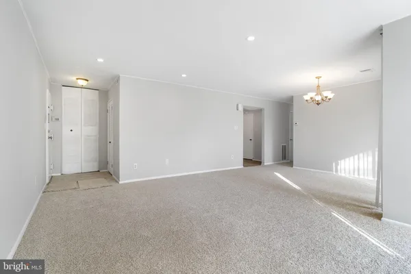 a view of a big room with windows and chandelier fan