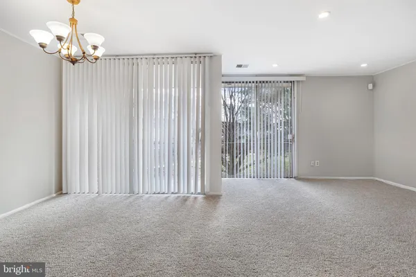 en empty room with windows and a chandelier