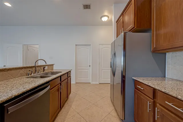 a kitchen with stainless steel appliances granite countertop a refrigerator and a sink