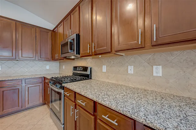 a kitchen with stainless steel appliances granite countertop a sink a stove and cabinets