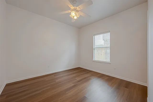 a view of a room with wooden floor and a ceiling fan