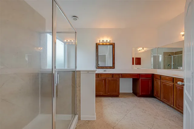a large bathroom with a large mirror vanity and shower