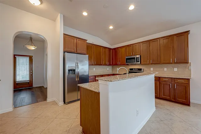 a kitchen with stainless steel appliances granite countertop a refrigerator stove top oven a sink and dishwasher