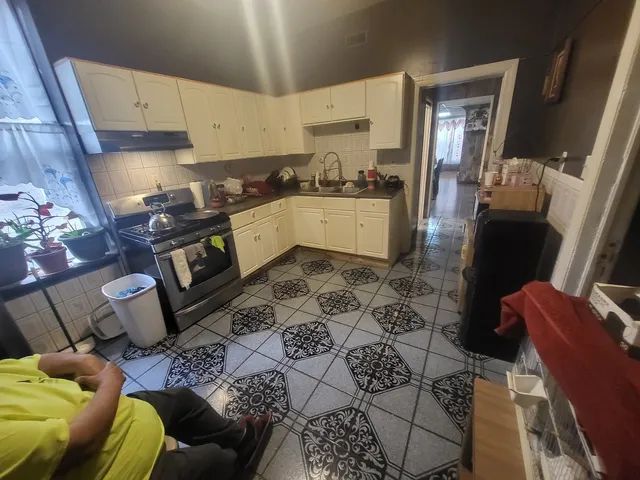 a room with stainless steel appliances kitchen island granite countertop lots of clutter