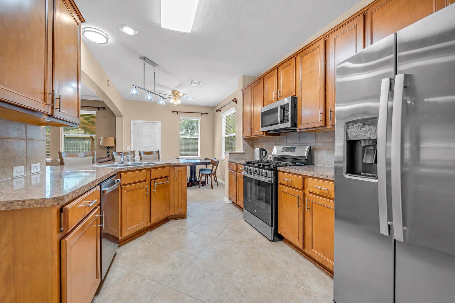 5406 Quarry Ridge Road Richmond, TX 77407 - Photo 17 of 36 Spacious U-shaped kitchen with abundant cabinetry, breakfast bar seating, stainless steel appliances, and an open layout that keeps everyone connected from cooking to conversation.