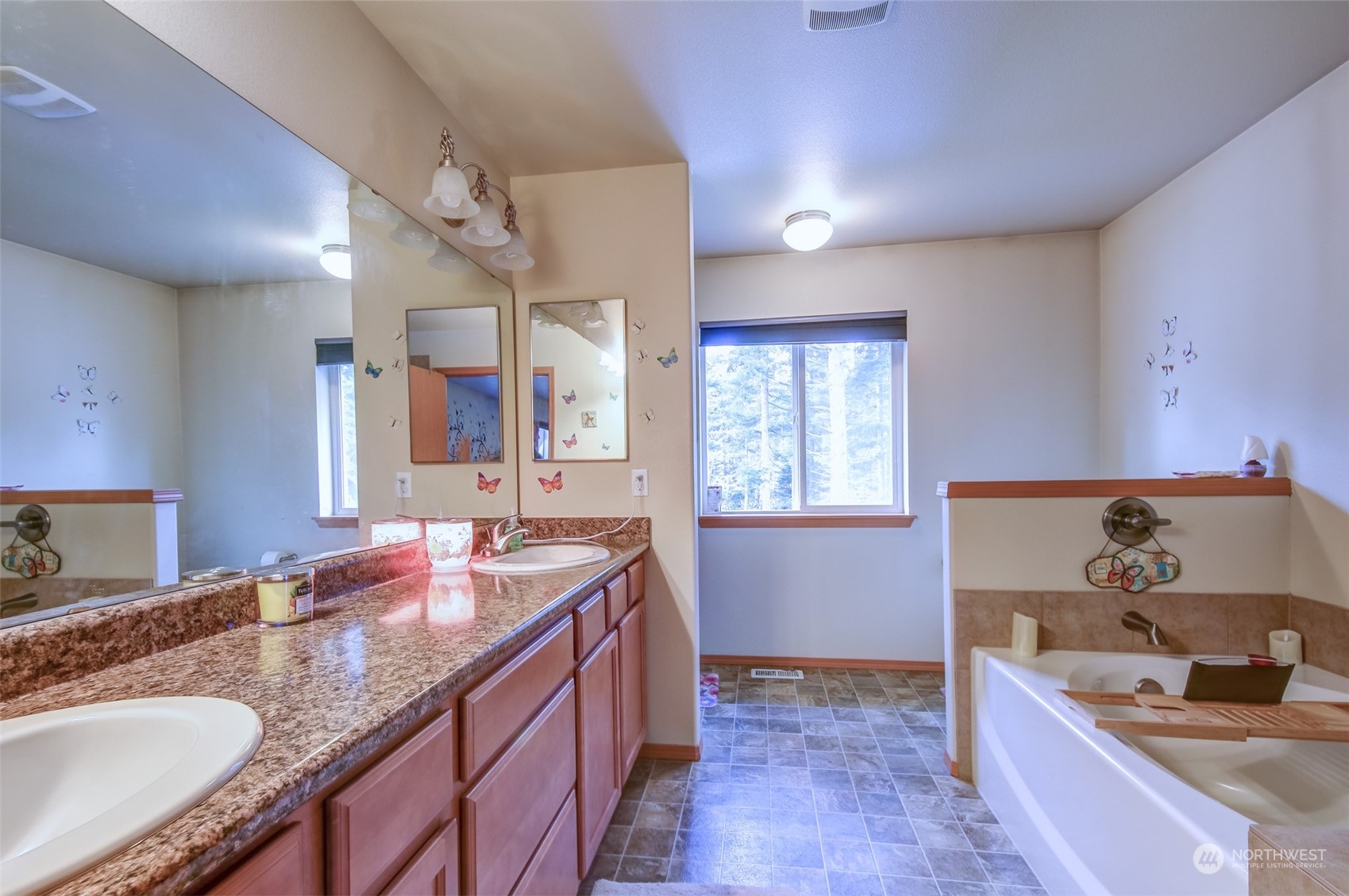 4644 Chanting Circle Southwest Port Orchard, WA 98367 - Photo 12 of 26 a bathroom with a granite countertop double vanity sink a mirror and a bathtub