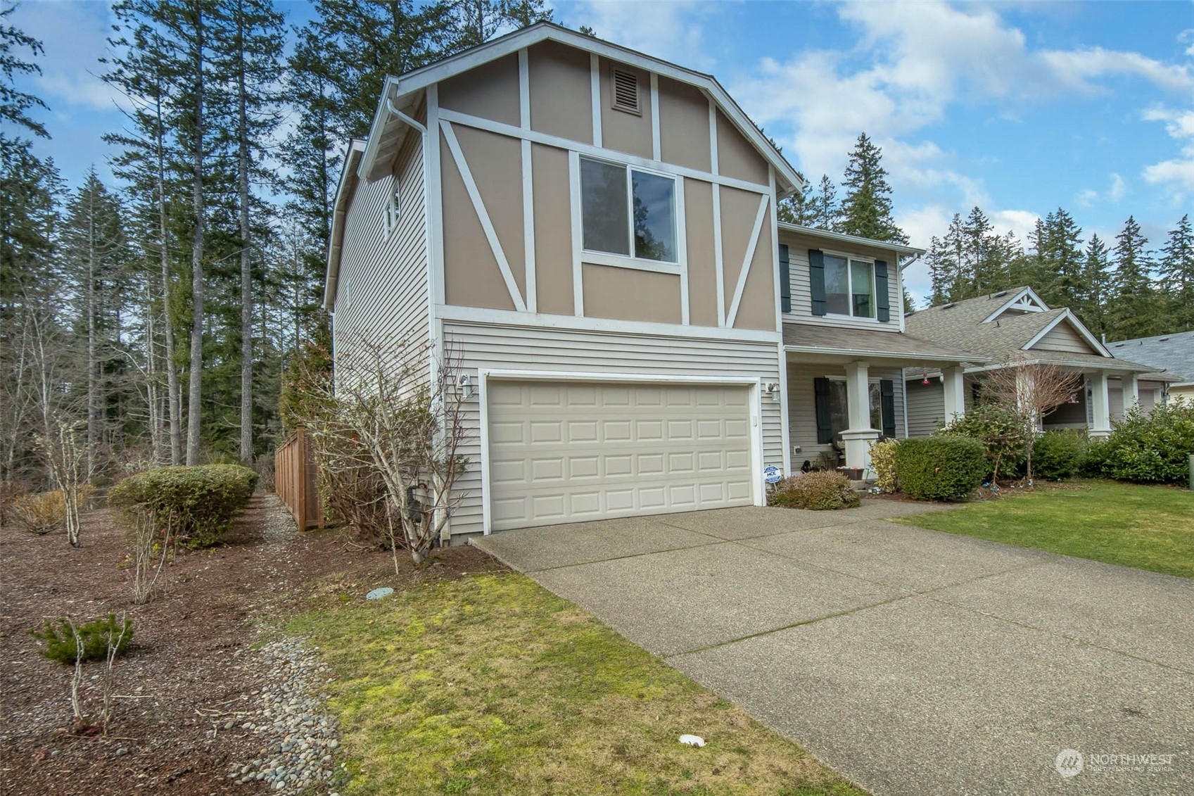 4644 Chanting Circle Southwest Port Orchard, WA 98367 - Photo 23 of 26 a front view of a house with a yard and garage