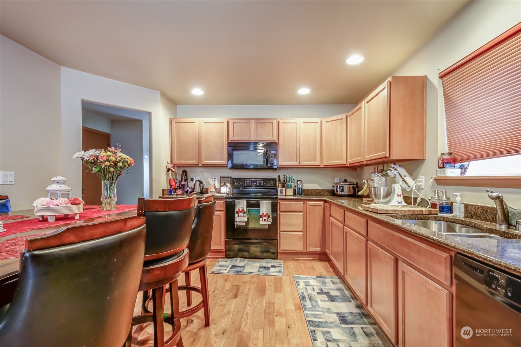 4644 Chanting Circle Southwest Port Orchard, WA 98367 - Photo 7 of 26 a kitchen with granite countertop kitchen island stainless steel appliances a sink dishwasher a refrigerator oven and white cabinets next to a window