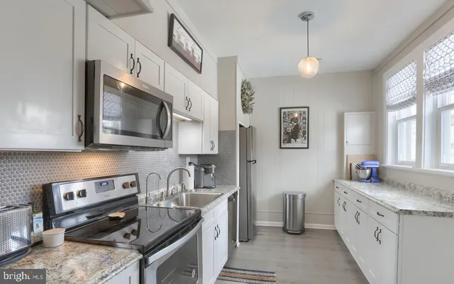a kitchen with sink a stove and cabinets