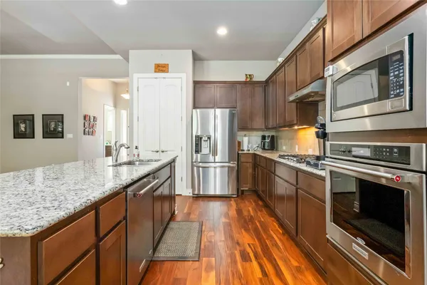 a kitchen with granite countertop stainless steel appliances and wooden cabinets