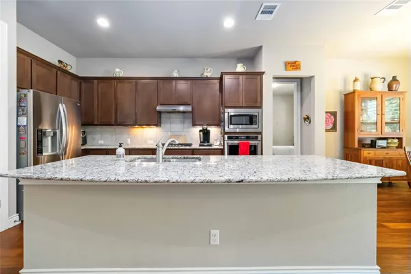 a kitchen with granite countertop a sink a refrigerator and a granite counter tops