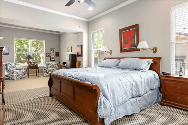 a spacious bedroom with a balcony a bed and glass windows