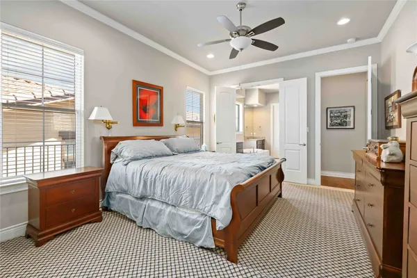 a spacious bedroom with a bed a dresser and a window