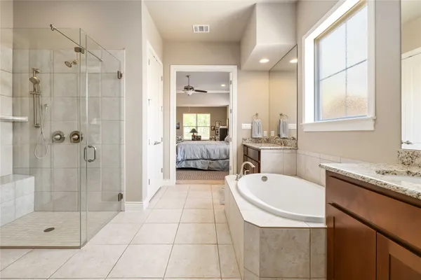 a bathroom with a tub sink shower and mirror