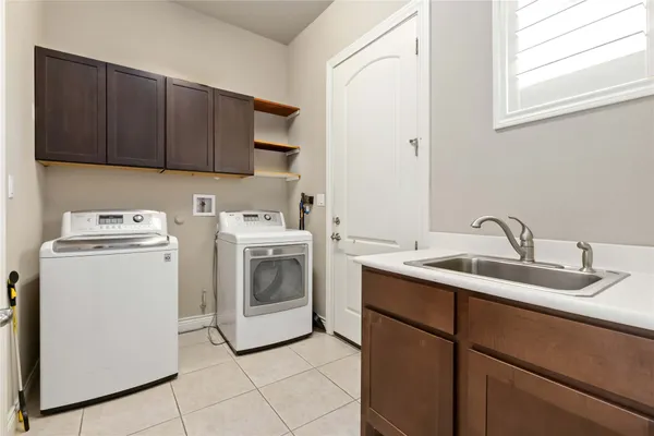 a utility room with sink dryer and washer