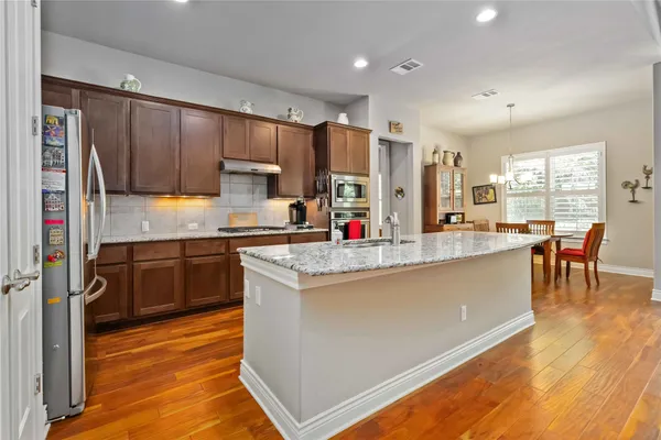 a kitchen with stainless steel appliances granite countertop a stove and a refrigerator