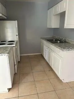 a kitchen with a sink a stove and a refrigerator