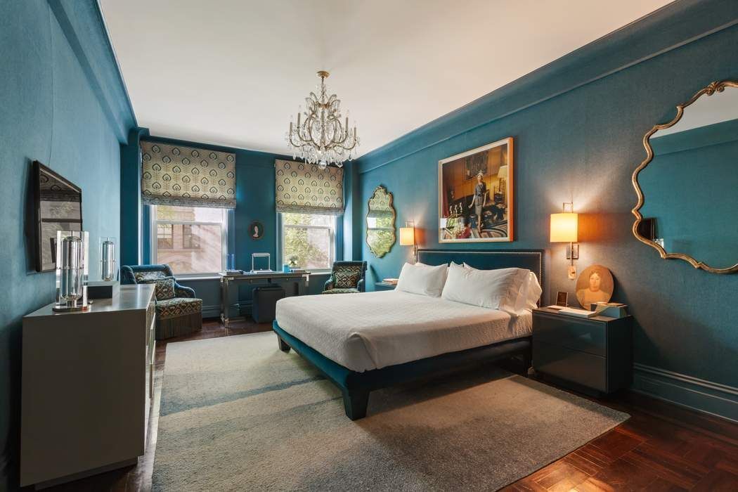 29 East 64th Street, Unit 4C Manhattan, NY 10065 - Photo 7 of 9 a spacious bedroom with a bed and a chandelier