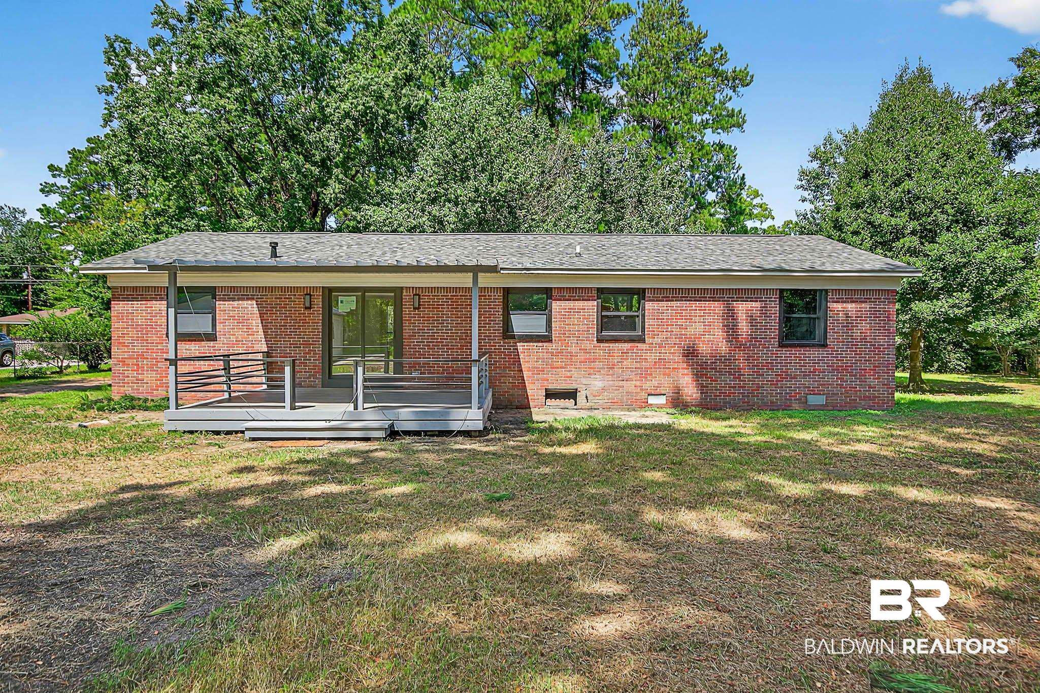 101 Terry Avenue Brewton, AL 36426 - Photo 5 of 48 Rear view of property featuring a lawn, a deck, brick siding, and crawl space