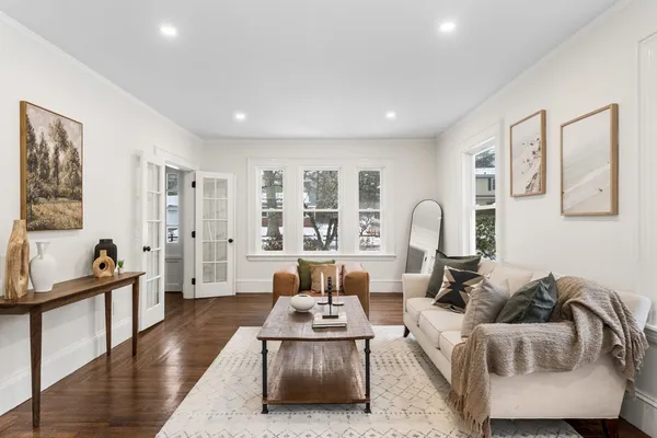 a living room with furniture and a wooden floor
