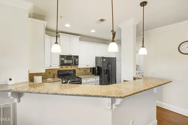 a kitchen with granite countertop kitchen island stainless steel appliances sink stove microwave and refrigerator