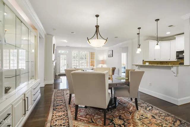 a dining room with furniture a chandelier and wooden floor