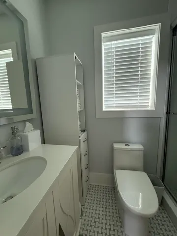 a bathroom with a sink a toilet and a window