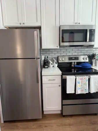 a kitchen with stainless steel appliances granite countertop a refrigerator stove a microwave and cabinets