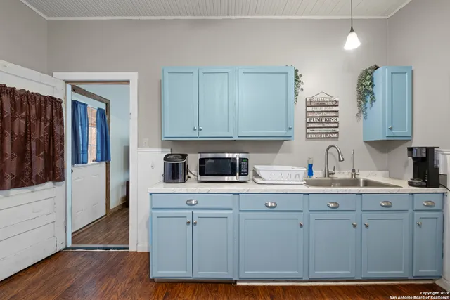 a kitchen with white cabinets and sink