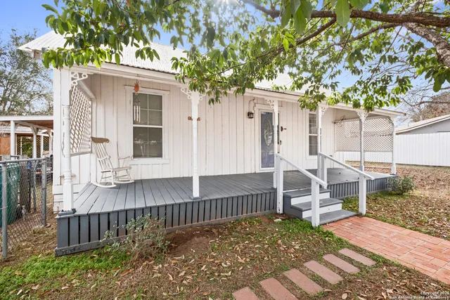 a view of a house with a small yard and wooden fence