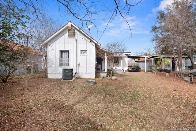 a view of a house with a yard and large tree