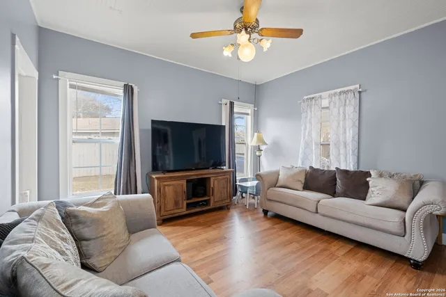 a living room with furniture flat screen tv and window