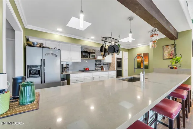 a kitchen with stainless steel appliances kitchen island granite countertop a table and chairs in it