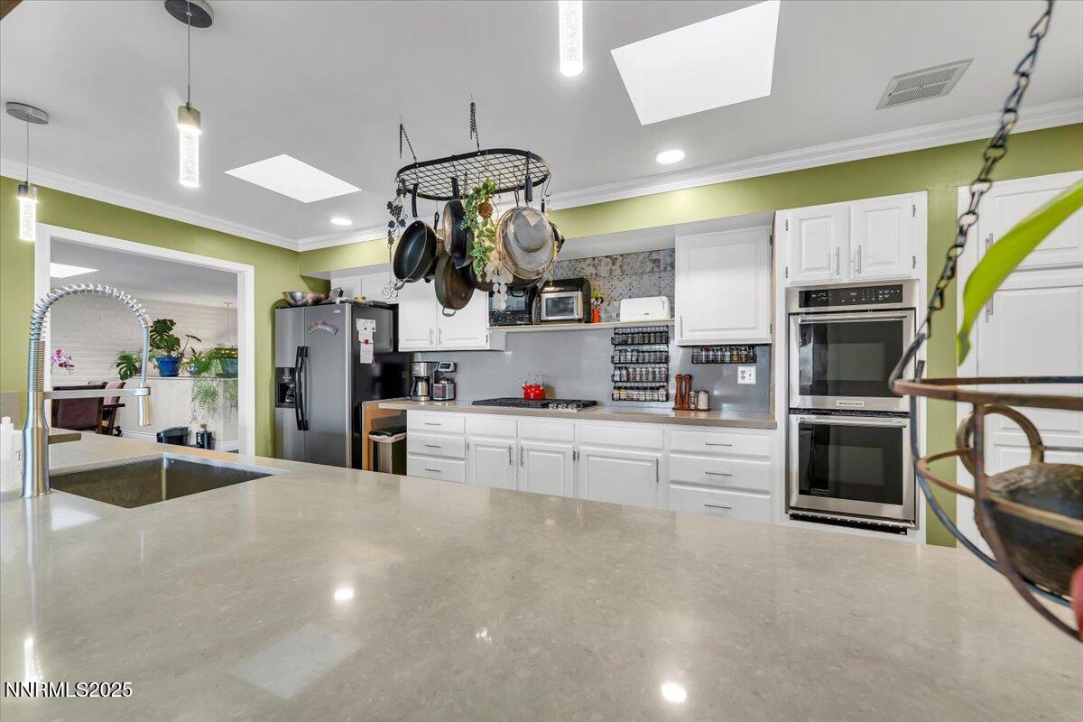 3415 Skyline Boulevard Reno, NV 89509 - Photo 14 of 49 a kitchen with stainless steel appliances kitchen island granite countertop a stove and cabinets