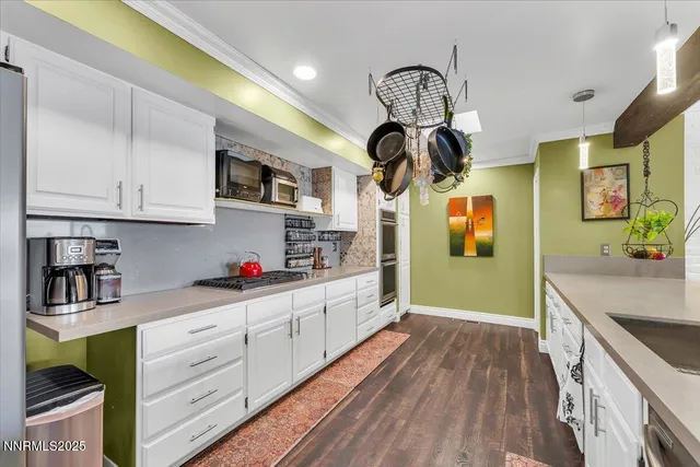 a kitchen with stainless steel appliances granite countertop a stove a sink and dishwasher cabinets with wooden floor