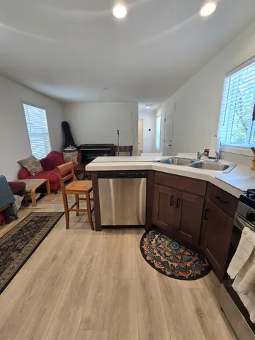 a living room with furniture a flat screen tv and kitchen view