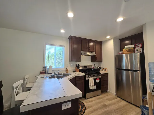 a kitchen with kitchen island a sink appliances and a counter top space