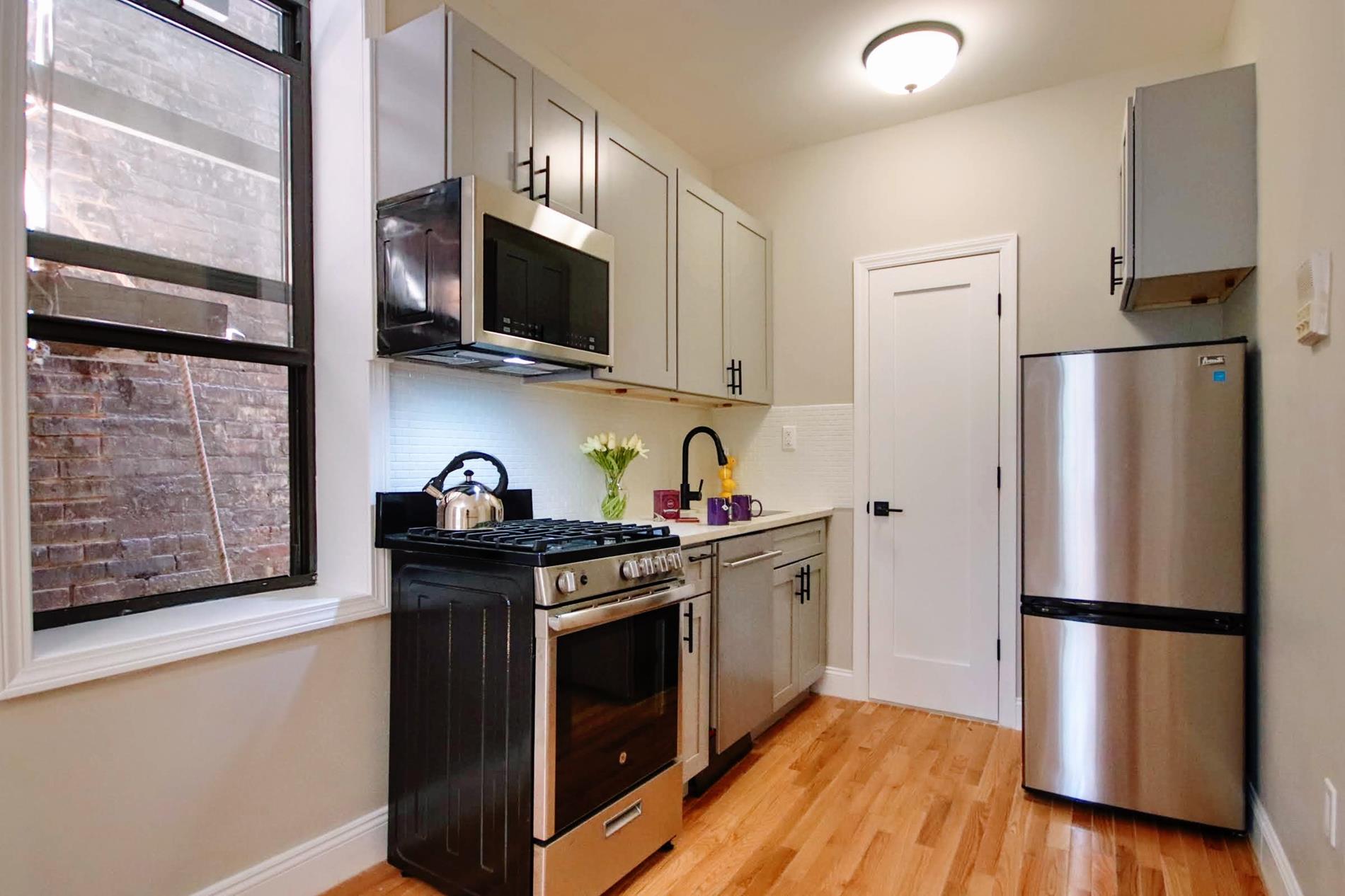 a kitchen with stainless steel appliances a refrigerator microwave and sink