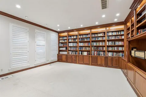 a view of an empty room with a bookshelf and a window
