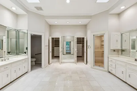 a large bathroom with a large mirror vanity and shower