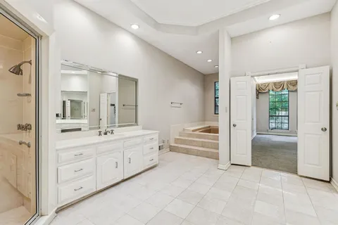 a bathroom with a granite countertop sink mirror and bathtub