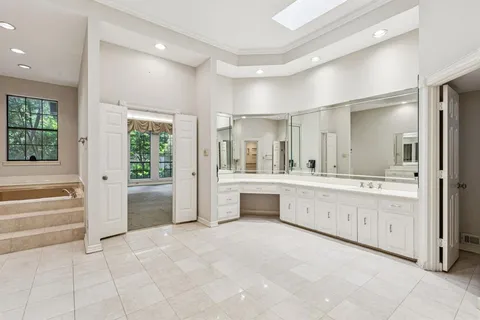 a large white bathroom with a granite countertop sink mirror and bathtub