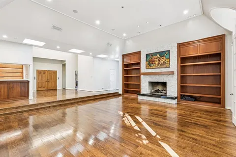 a view of an empty room with a fireplace and a window