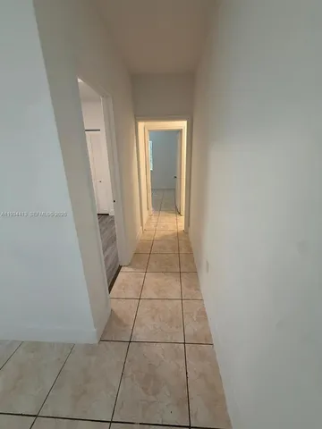 an empty room with wooden floor and window