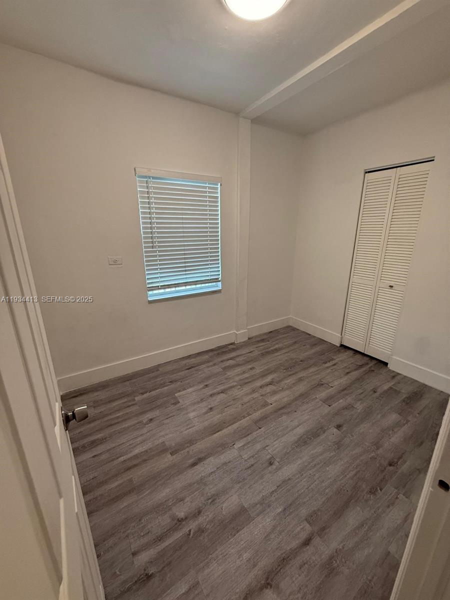 6909 Northwest 2nd Avenue, Unit 6909 Miami, FL 33150 - Photo 4 of 9 an empty room with wooden floor and window