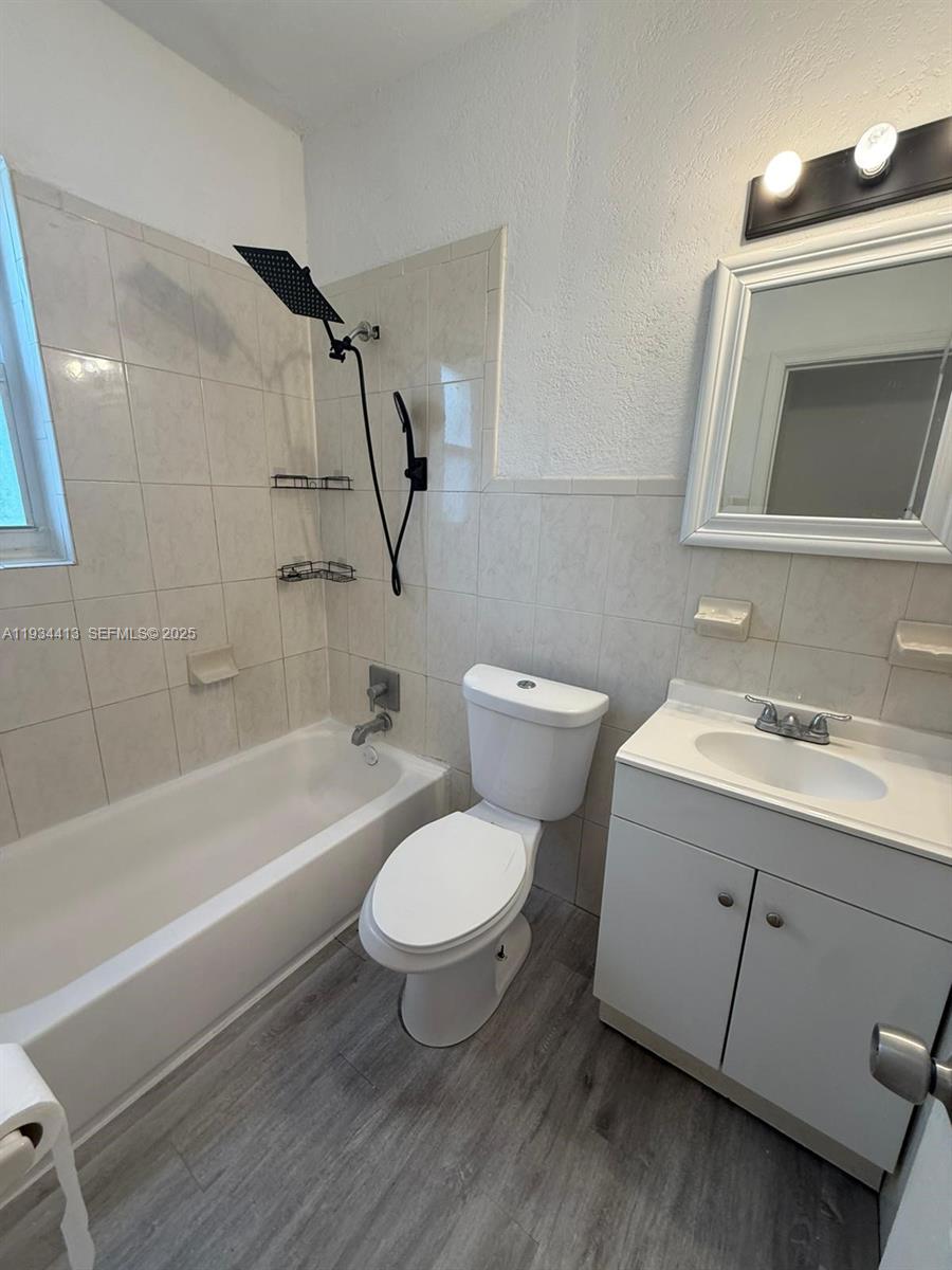 6909 Northwest 2nd Avenue, Unit 6909 Miami, FL 33150 - Photo 8 of 9 a bathroom with a sink toilet a mirror and bathtub